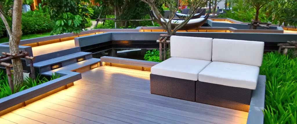 A composite deck featuring white furniture and string lights, creating a cozy outdoor atmosphere.