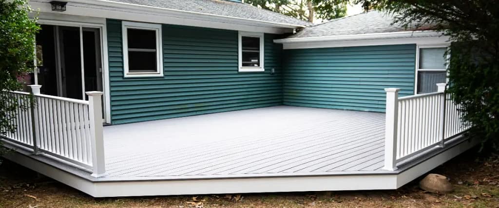 A composite featuring a white railing and blue siding, showcasing a clean and modern outdoor space.