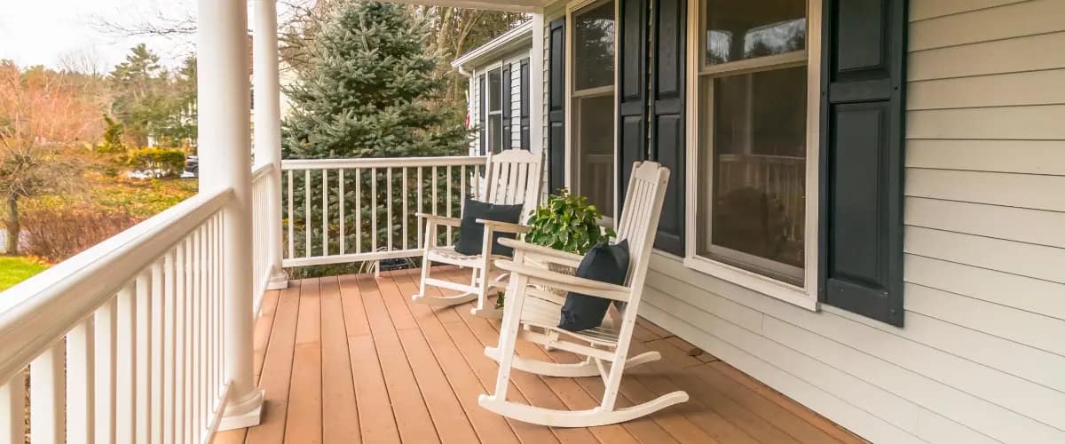 A cozy porch featuring wooden decking, inviting relaxation and conversation. A cozy porch featuring wooden decking, inviting relaxation and conversation.